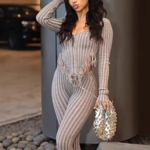 Detailed view of grey and pink striped knitted set featuring hand-crocheted fringe