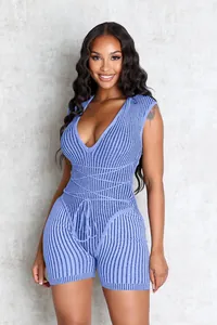 Détail d'une combinaison en maille côtelée bleue avec col en V profond et cordon de serrage