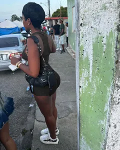 Streetstyle weergave van een vrouw in een sexy donkerolijfgroene geribbelde mini-romper