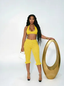 Stylish yellow and black polka dot two-piece halter top and cropped pants set