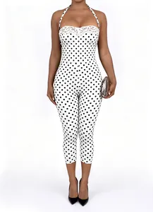 Detail view of a white polka dot halter jumpsuit with lace trim and slim fit design.