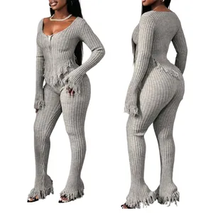 Detailed view of women's grey knitted two-piece set featuring handmade tassel fringe.