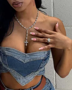 Detail of a sexy heart-shaped washed denim tube top with silver jewelry.