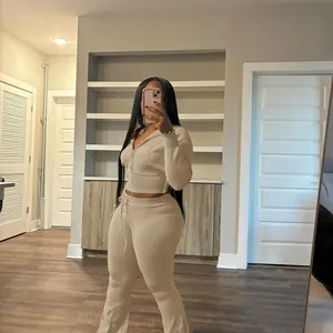 Detail view of a beige knit two-piece set featuring a cropped hoodie and flared pants