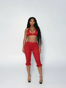 Model wearing a sexy red and white polka dot two-piece halter top and cropped pants set