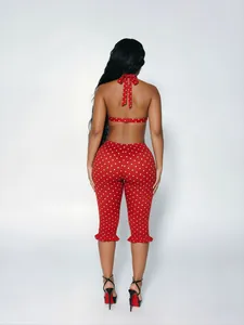 Back view of a sexy red and white polka dot two-piece halter top and cropped pants set