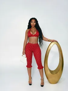 Stylish red and white polka dot two-piece set with a halter crop top and ruffled hem pants