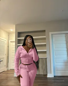 Detail view of pink knitted hoodie and jogger set worn by a model in home setting