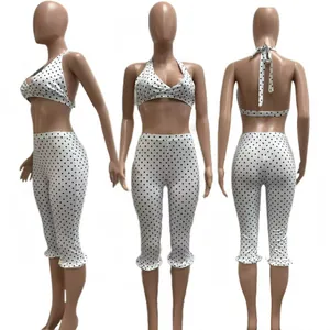 Fashionable white and black polka dot two-piece set featuring halter top and ruffled capris