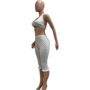 Side view of stylish white two-piece outfit with black polka dots and halter neck crop top