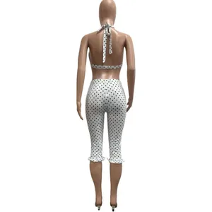 Back view of white polka dot two-piece set featuring halter top and cropped leggings