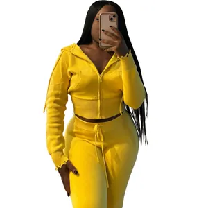 Detailed view of yellow knit tracksuit set featuring hooded zip-up top and drawstring pants