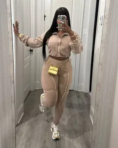 Full body mirror selfie of a woman wearing a beige washed distressed tracksuit set