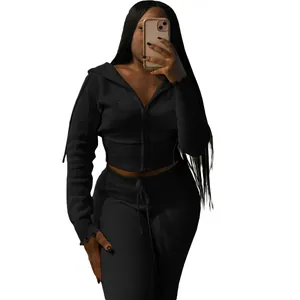 Detailed view of women's black knitted two-piece tracksuit with zip-up hoodie and pants.
