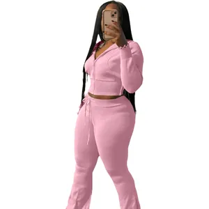Two-piece pink knitted sports set featuring a zip-up hoodie and matching drawstring pants.