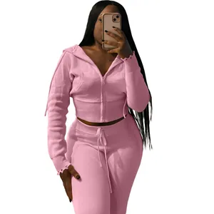 Detail shot of pink knitted tracksuit showing ribbed texture and drawstring waist.