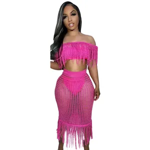 Detail of sexy hot pink crochet beach set featuring fringe off-shoulder top and skirt.