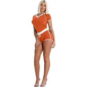 Detail of orange athletic two-piece set with V-neck top and shorts in yoga fabric