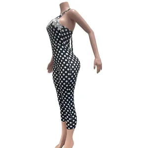 Side view of a sexy black polka dot jumpsuit with white lace trim and halter neck