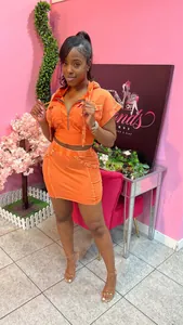 Detail view of women's orange acid wash two-piece hooded top and skirt set.