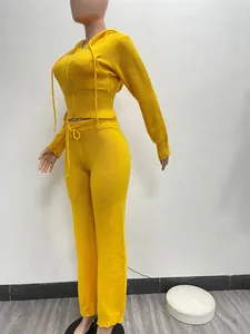 Full view of vibrant yellow two-piece knit tracksuit featuring hooded top and pants