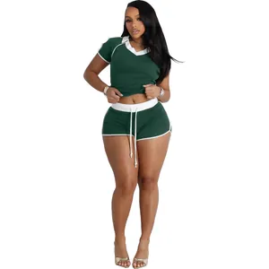 Detail showing two-piece dark green sportswear set with white ribbed trim and V-neck