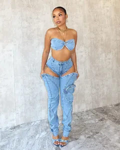 Dettaglio del set in denim lavato con top a fascia e pantaloni con tagli e zip