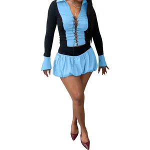 Detailaufnahme eines sexy Langarmtops mit Schnürung und passendem blauem Puffy-Skort-Set.