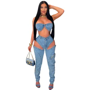 Dettaglio di un completo denim sexy a due pezzi con top a fascia e pantaloni cut-out con zip.