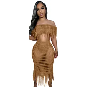 Sexy two-piece brown crochet knit beach set with fringe detailing on crop top and midi skirt