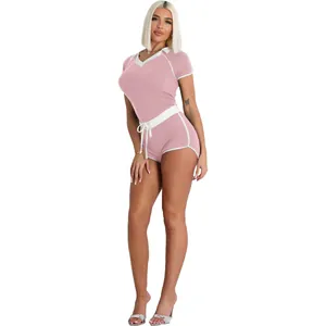 Close-up detail of the pink two-piece athletic lounge set with V-neck and white trim accents