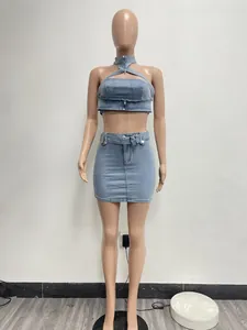 Vista frontal de un conjunto de dos piezas de top halter y minifalda en denim lavado.