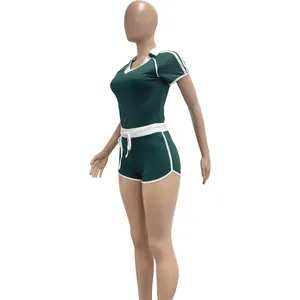 Detail view of women's green two-piece athletic yoga set with white contrast piping
