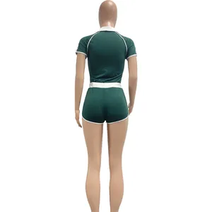 Back view of a two-piece green sports set with white piping on a mannequin.