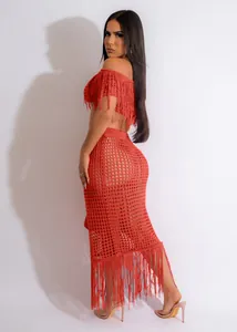 Detailed view of sexy orange-red crochet knit beach set featuring long fringe details