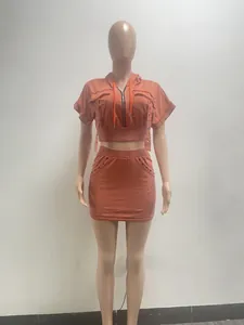 Detailed view of women's orange acid wash hooded crop top and mini skirt matching set.