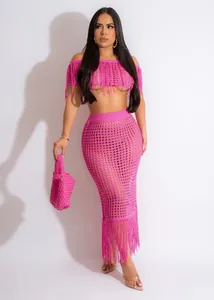 Professional detail view of a pink crochet two-piece beach set with elegant tassels on a model