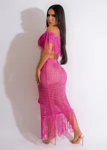 Detail view of sexy pink crochet beach two-piece set featuring tassels and knit fishnet skirt