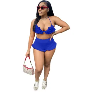 Detailed view of sexy blue ruffle halter top and high-waisted shorts set on model