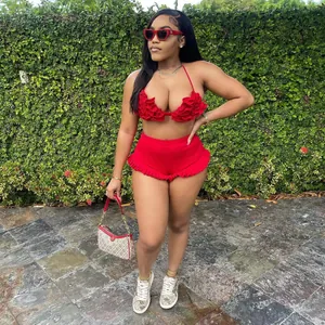 Stylish red two-piece set featuring ruffled halter neck top and frilly shorts on model.