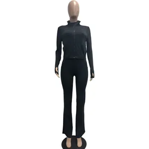 Schwarzes zweiteiliges Sportset mit schmal geschnittener Jacke und ausgestellter Hose.