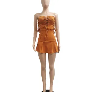 Detailed view of an orange sleeveless dress with sexy lace-up hollow design and pleated hem.