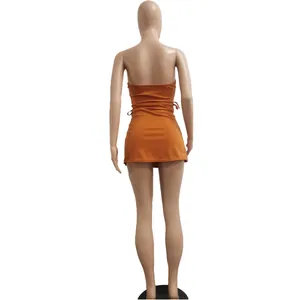 Rear perspective of a stylish orange sleeveless backless mini dress shown on a mannequin