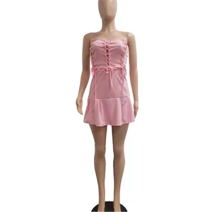 Pink strapless mini dress featuring decorative lace-up grommet details on the bodice.