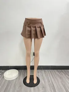 Close-up detailed view of a brown faux leather pleated mini skirt displayed on a mannequin