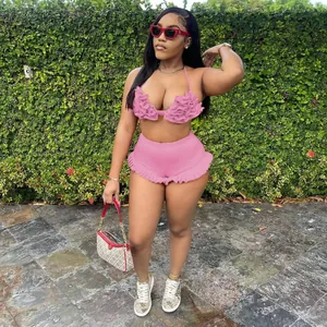 Fashionable pink ruffled halter crop top and matching shorts set for women in garden