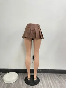 Macro view of the sexy brown faux leather pleated mini skirt on a mannequin stand.