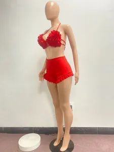 Detail of stylish red two-piece set featuring floral halter top and ruffled shorts.