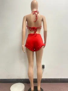 Back view of red halter neck lace-up top and ruffled shorts set shown on mannequin