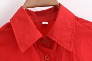Gros plan détaillé d'un col de chemise rouge avec boutons et une étiquette de taille S